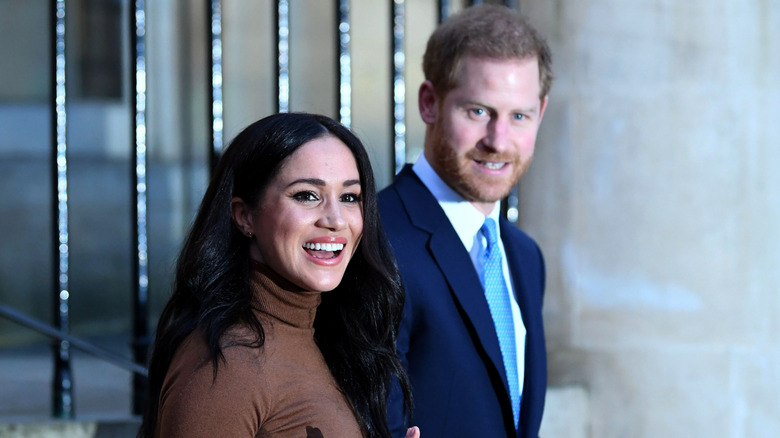 Meghan Markle and Prince Harry smiling and waving to the cameras