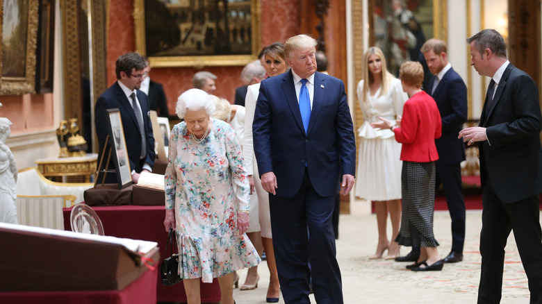 Donald Trump walking at Buckingham Palace in 2019 with Prince Harry in the background