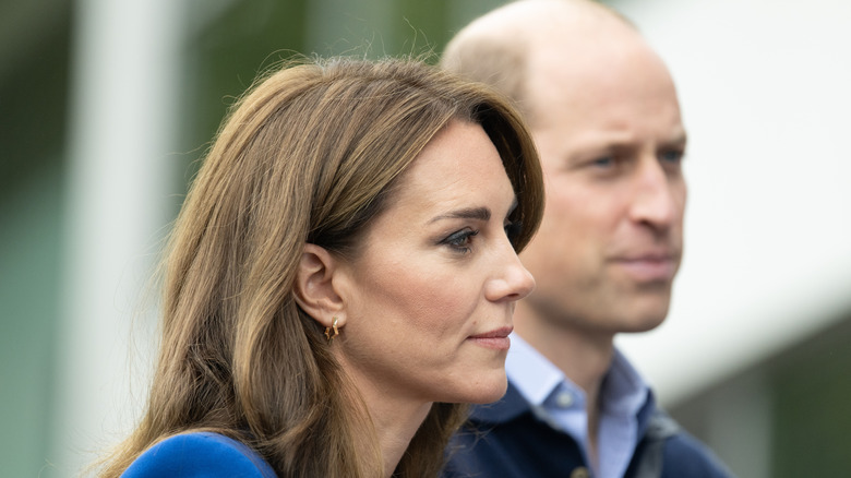 A profile shot of Kate Middleton with Prince William behind her