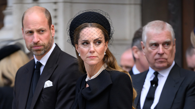 Prince William and Kate Middleton wearing all black with Andrew Mountbatten behind them