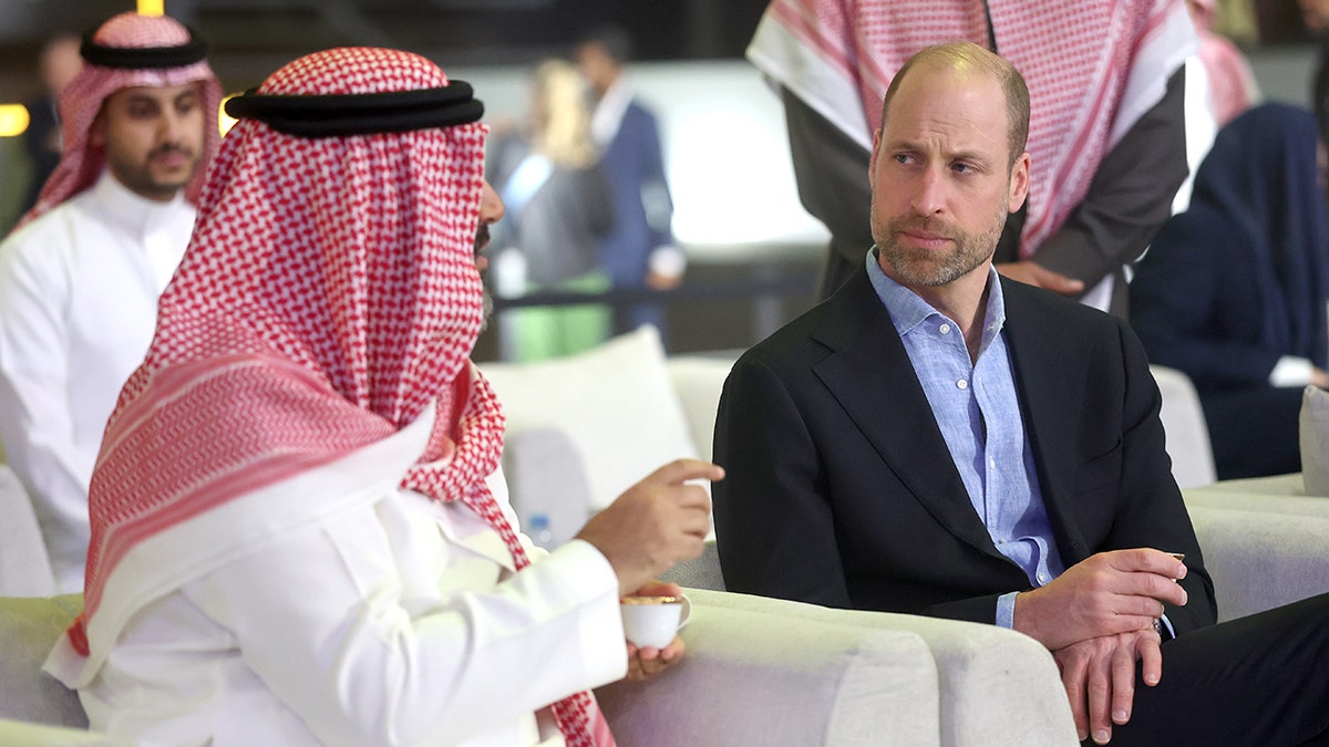 Prince William speaking to someone in Saudi Arabia during a conference.