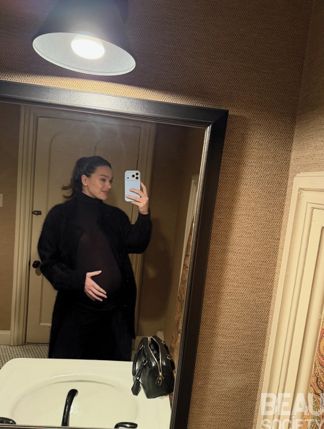Hailee Steinfeld styled a black maternity dress with a matching coat