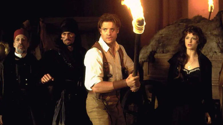 Brendan Fraser as Rick O'Connell, leading his party with a lit torch in The Mummy 1999.
