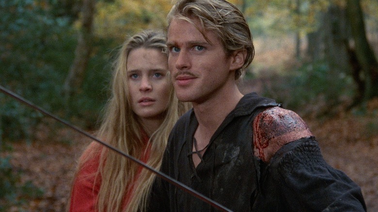 Robin Wright as Buttercup, standing behind Cary Elwes as Westley in the forest in The Princess Bride.