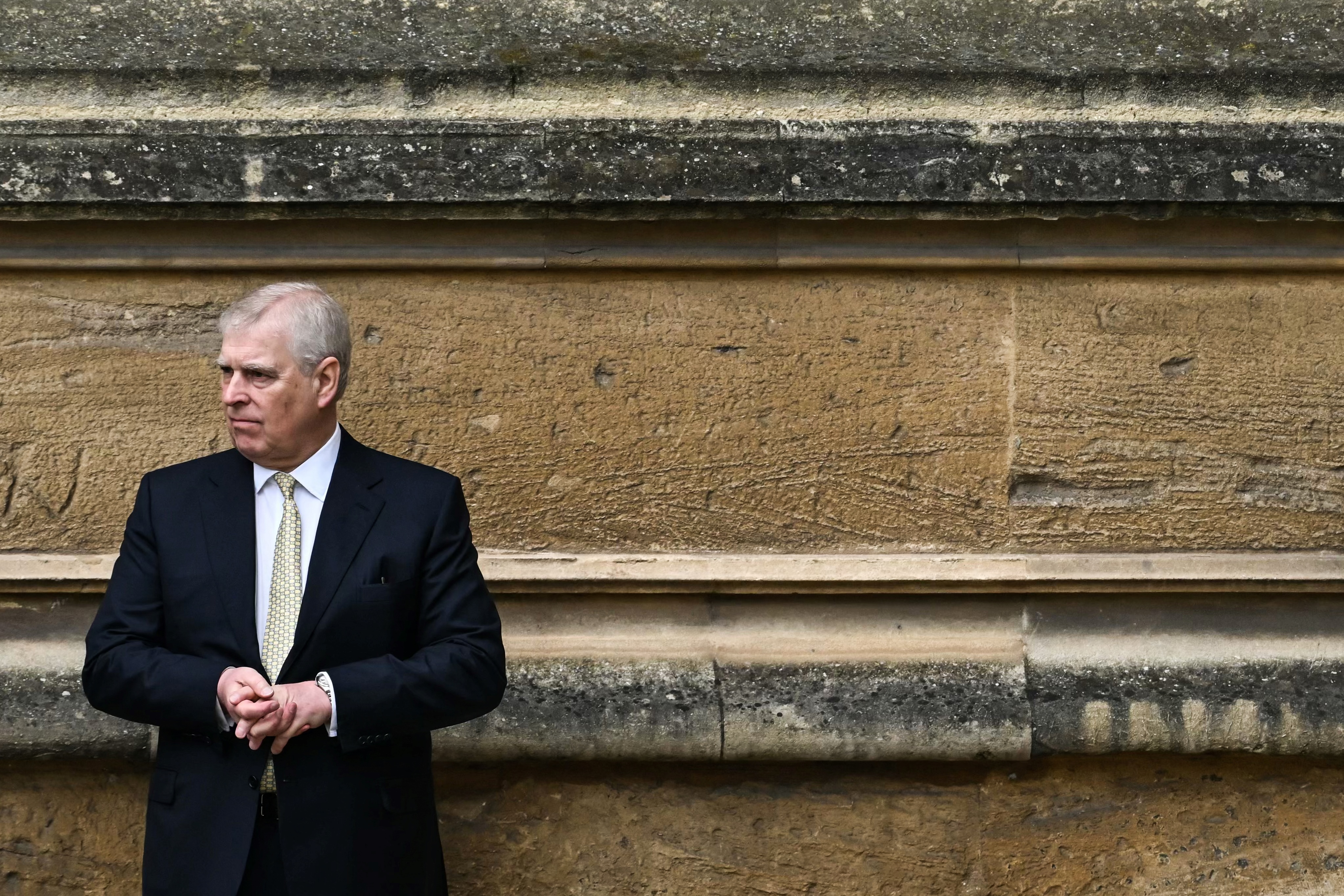 Andrew Mountbatten-Windsor standing along a wall at St George's Chapel