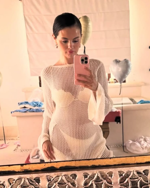 person holding a phone in a decorated room with a mirror and balloons