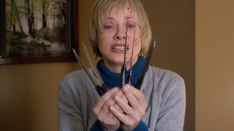 Anne holding five knives in 