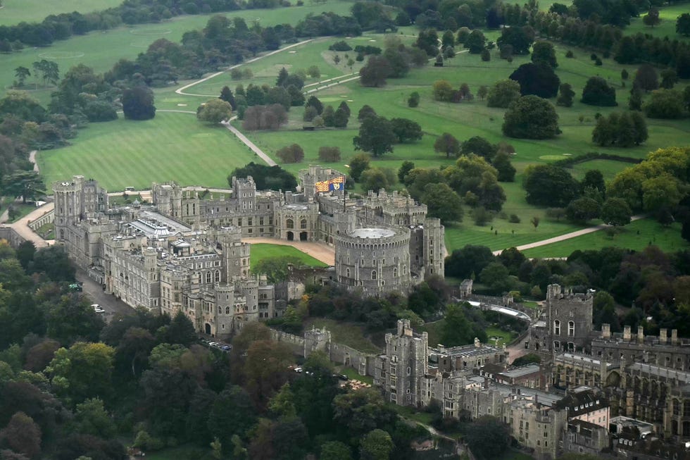 an aerial view shows the royal standard flag flying from atop the round tower at windsor castle, on the windsor estate, on september 18, 2025