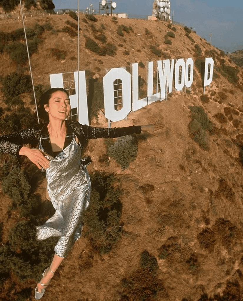 Michelle Yeoh photographed by Joe Mcnally flying over the iconic Hollywood sign while suspended from a helicopter for National Geographic in 1998 🚁