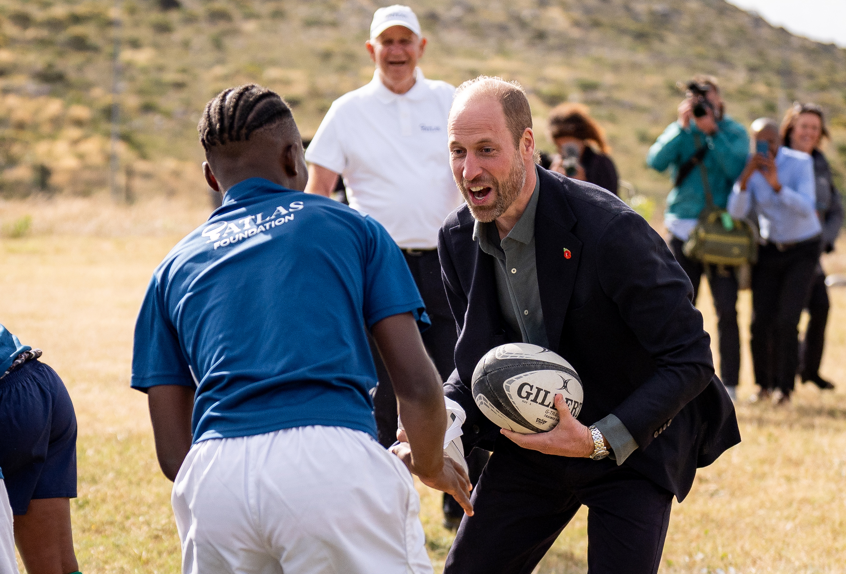 Prince William playing rugby with a man in South Africa