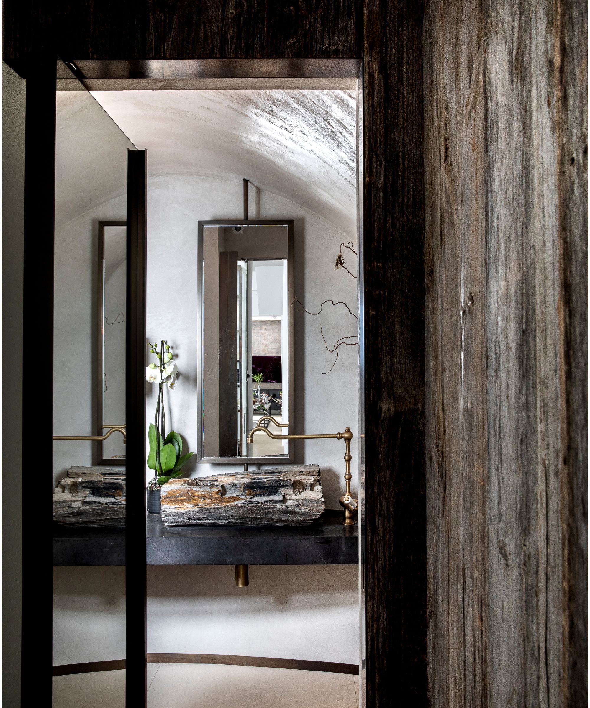 Bathroom with wood panels and a black marble vanity
