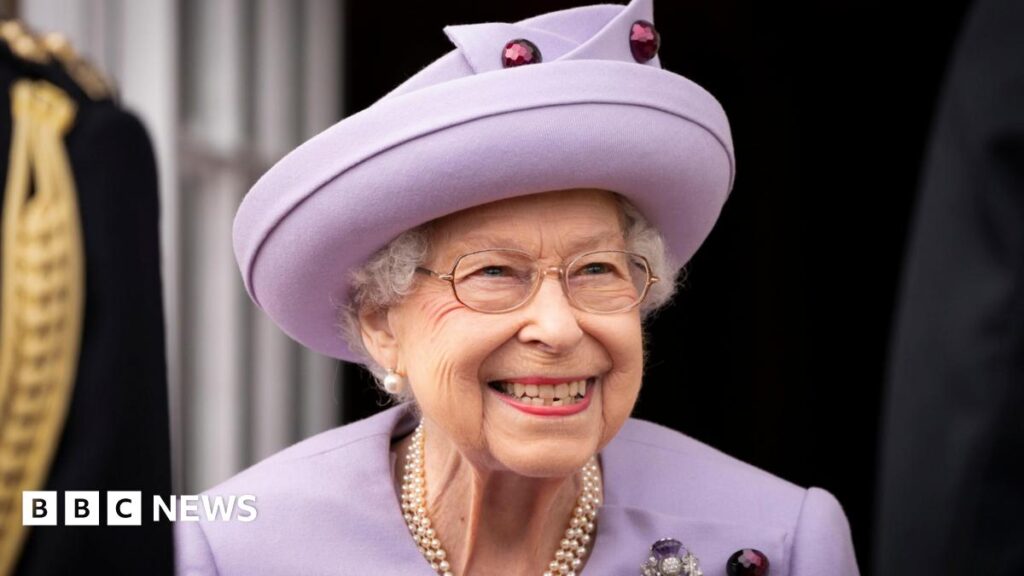 Image of the late Queen Elizabeth II smiling at an event at the Palace of Holyroodhouse, dressed in lilac.