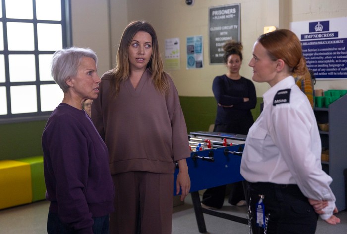 Lou and Debbie talk to a prison officer in Coronation Street