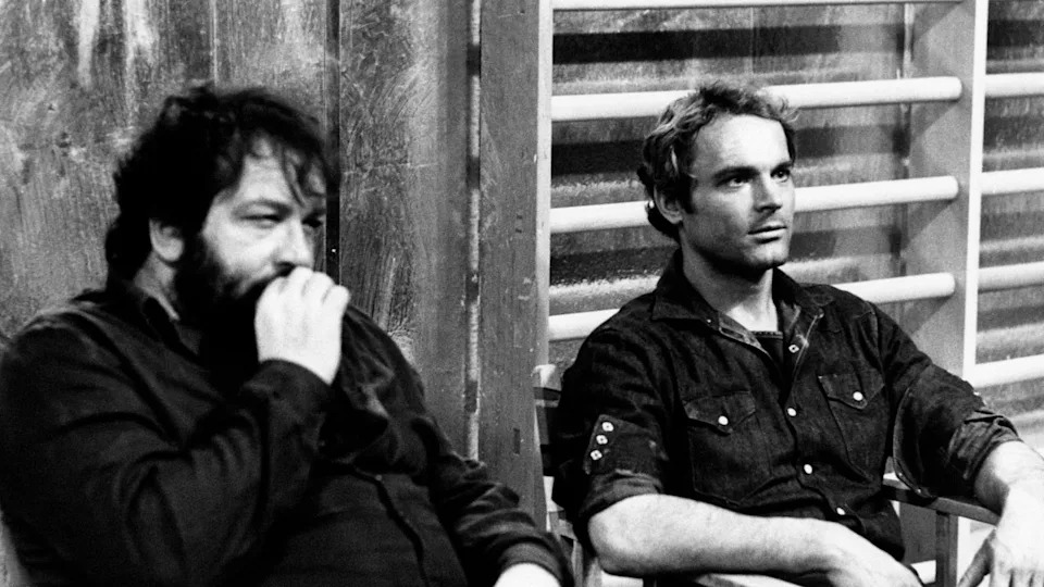 Italian actor Terence Hill sitting beside Italian actor Bud Spencer in the film Watch Out, We're Mad!.. in Rome, 1974. Mondadori via Getty Images