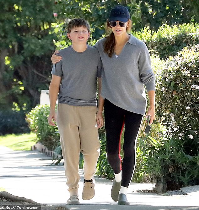 The next day garner wore a gray sweater and black leggings as she walked with her son