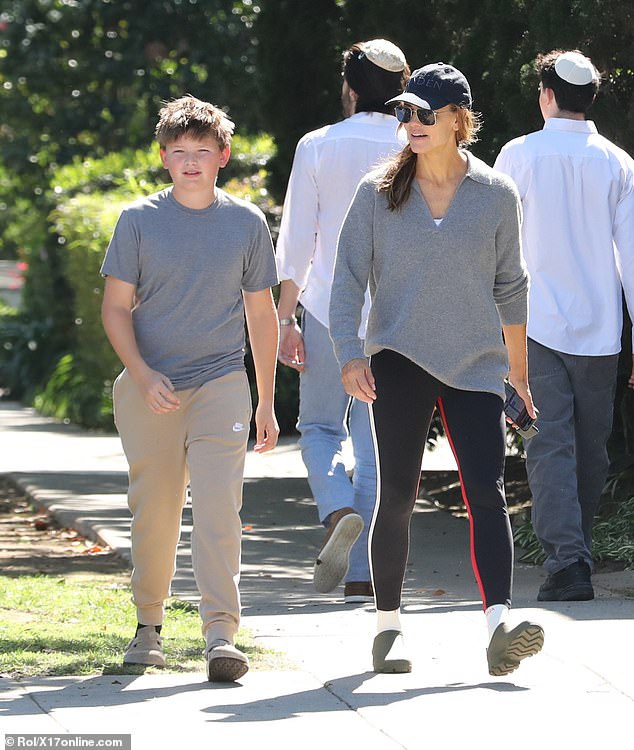 Samuel wore a pale gray T-shirt with beige Nike sweatpants and sandals