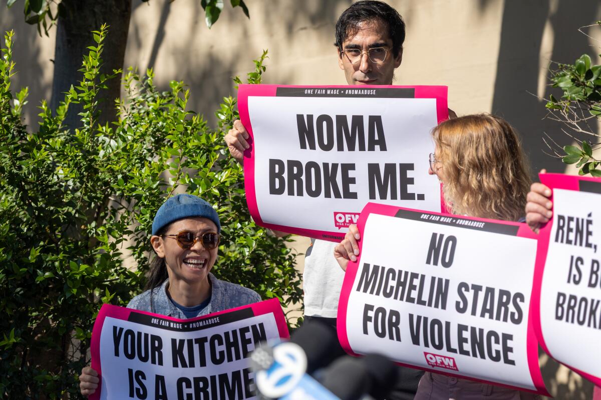People hold up signs.