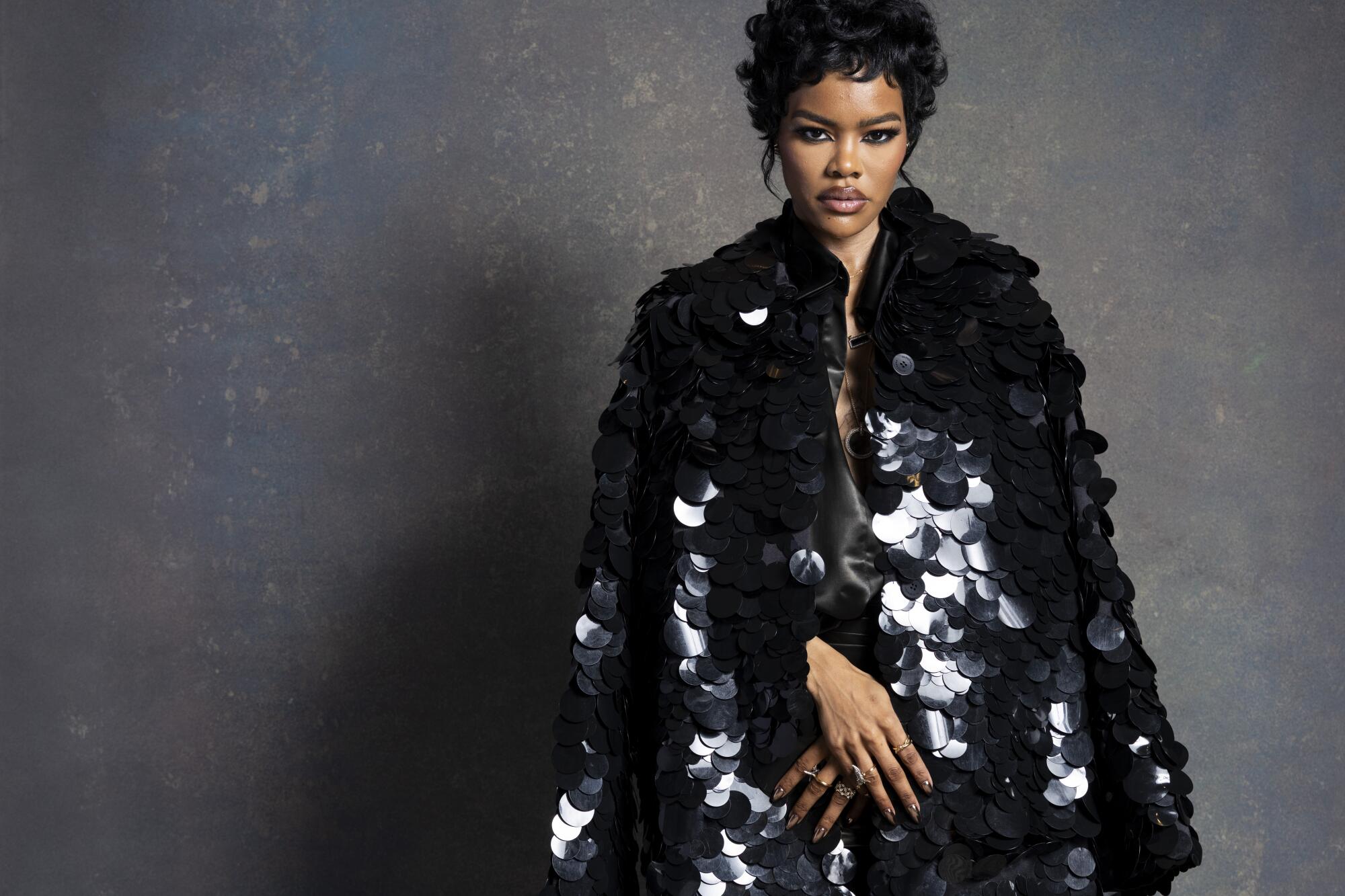 Actress Teyana Taylor wears a black sequined outfit and poses