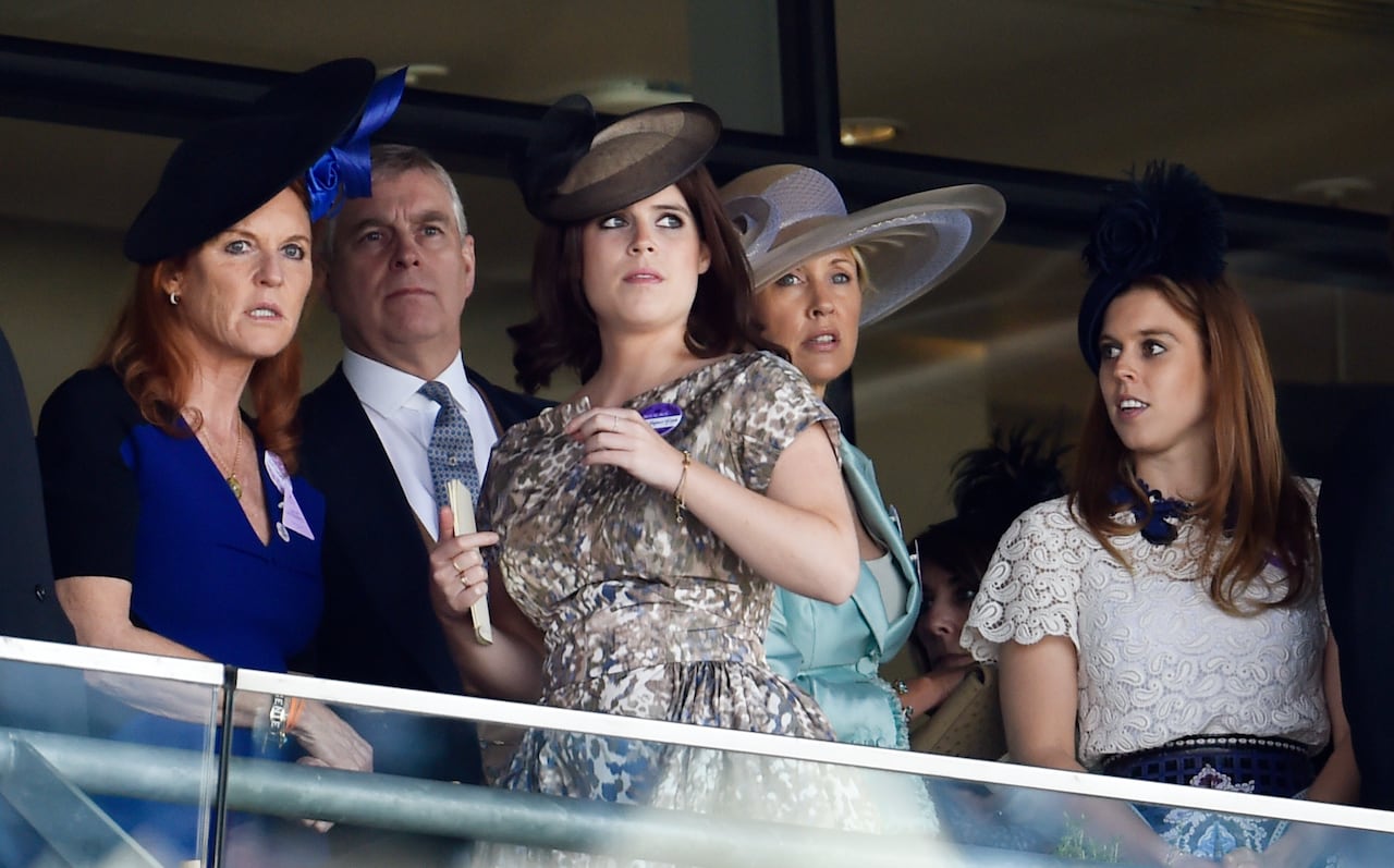 Five people stand together behind a railing.