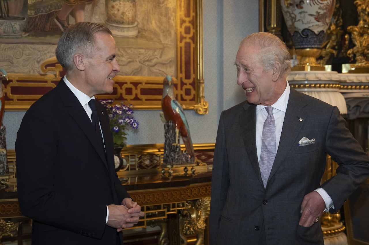 Two people smile as they talk with one another.