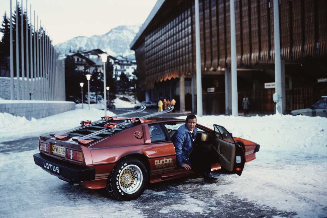 English actor Roger Moore poses as 007, with a Lotus Esprit Turbo, on the set of the James Bond film 'For Your Eyes Only' in Cortina d'Ampezzo, Italy, March 1981.
