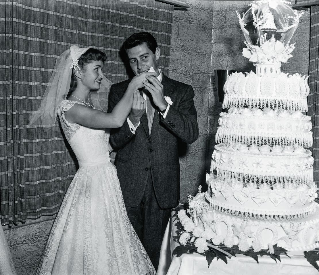 Debbie Reynolds feeds Eddie Fisher a slice of their wedding cake following their marriage at the Grossinger Resort in the Catskills in Grossinger, N.Y. on Sept. 26, 1955Credit: Bettmann Archive