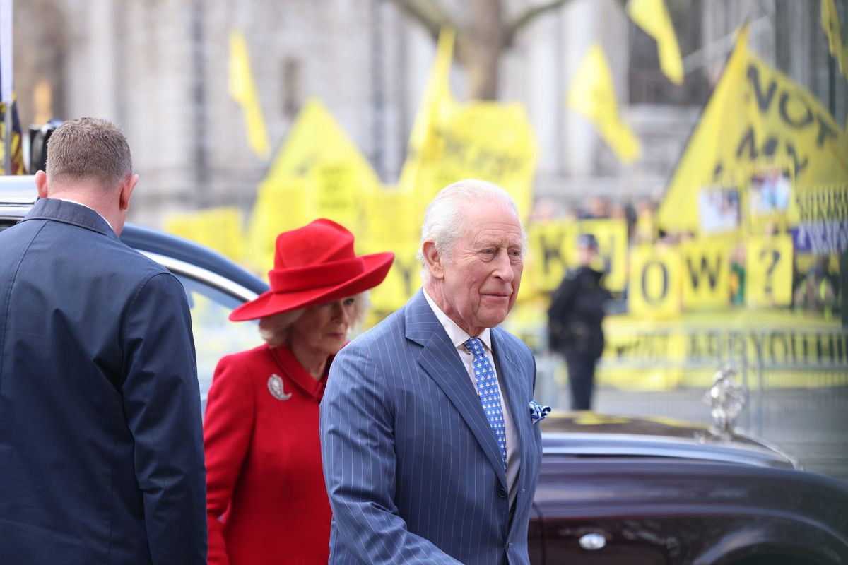 Charles and Camilla arrive for the service with protesters in the background 