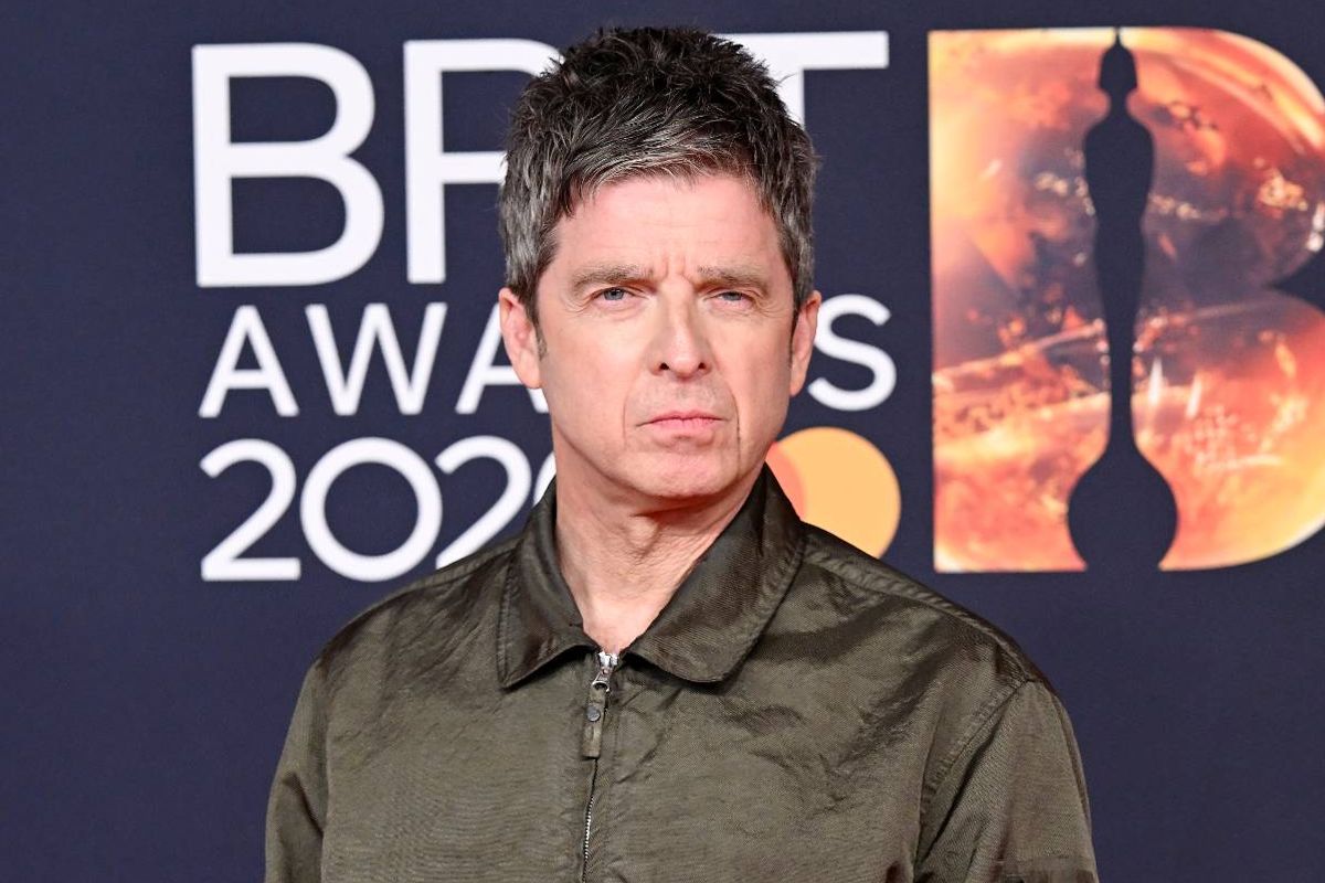 An individual in a green collared shirt standing in front of a backdrop featuring the text "BFI Awards 2022" and a vibrant fiery background.