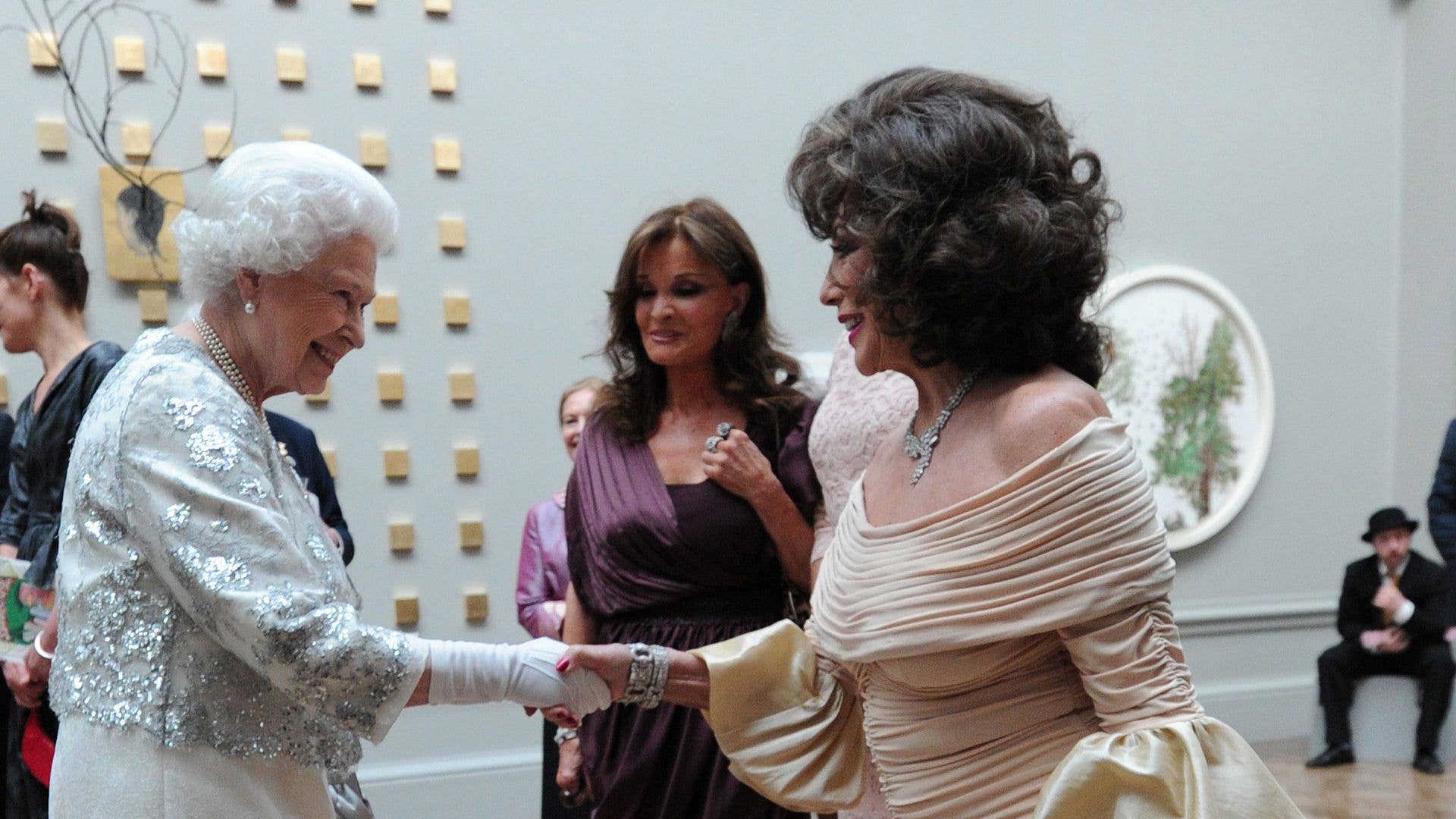 Joan Collins curtseying while meeting the late Queen