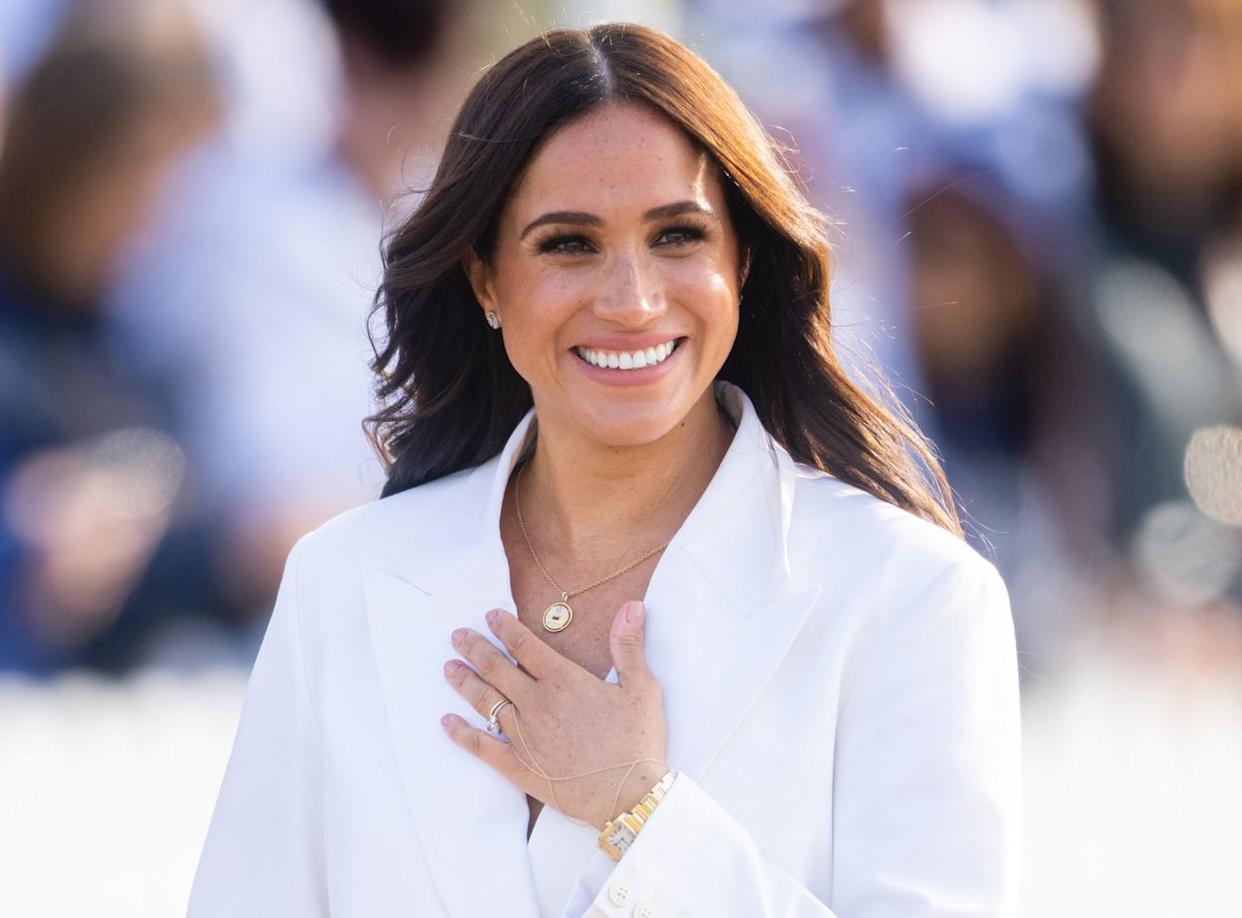 Meghan Markle holding her hand to her chest while smiling.Credit: Getty Images