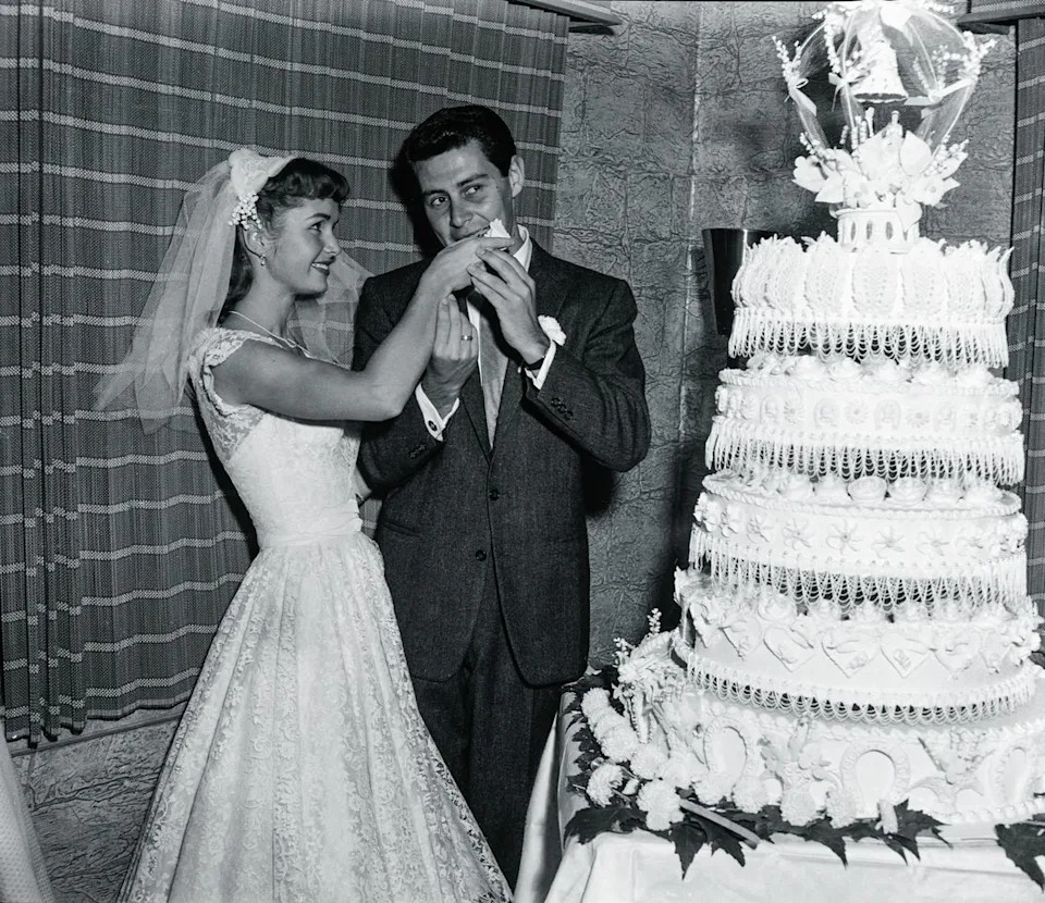 Debbie Reynolds feeds Eddie Fisher a slice of their wedding cake following their marriage at the Grossinger Resort in the Catskills in Grossinger, N.Y. on Sept. 26, 1955Credit: Bettmann Archive