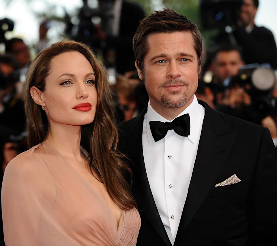 Two people on the red carpet; one in a flowing gown, the other in a classic tuxedo