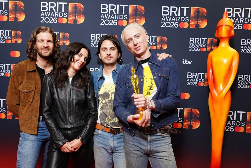 Wolf Alice hold their award up to the camera.