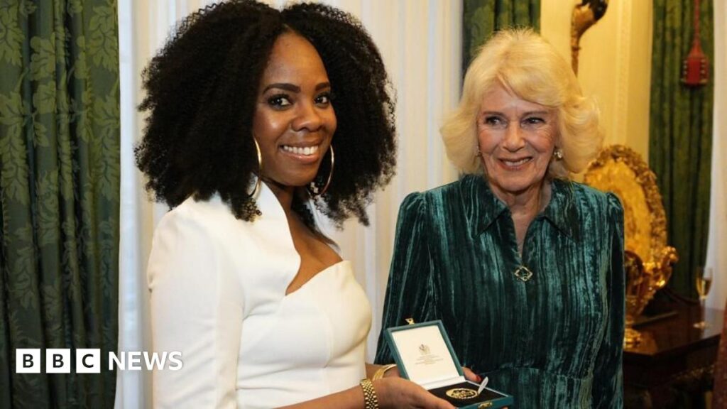 Queen Camilla presents Selina Brown with her medal during a reception for authors, members of the literary community and representatives from the Queen's Reading Room, to celebrate the first recipients of the Queen's Reading Room Medal, at Clarence House,