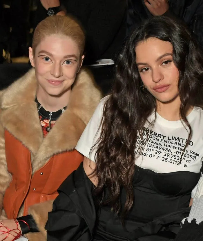 Four people seated at a fashion event, dressed in stylish, contemporary attire