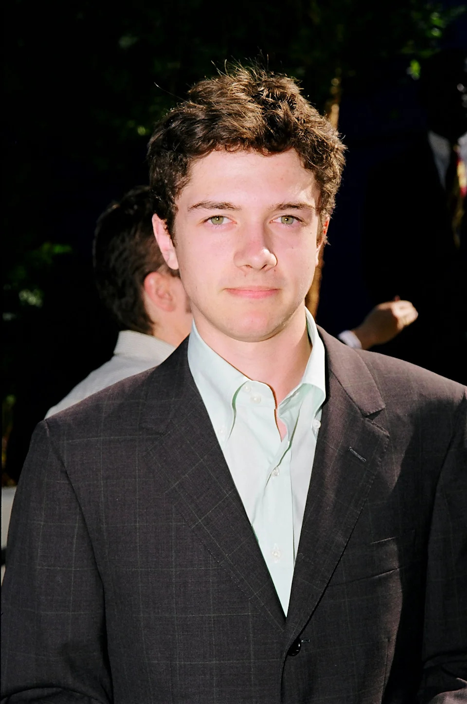 Topher Grace wearing a suit over a dress shirt is on a formal occasion