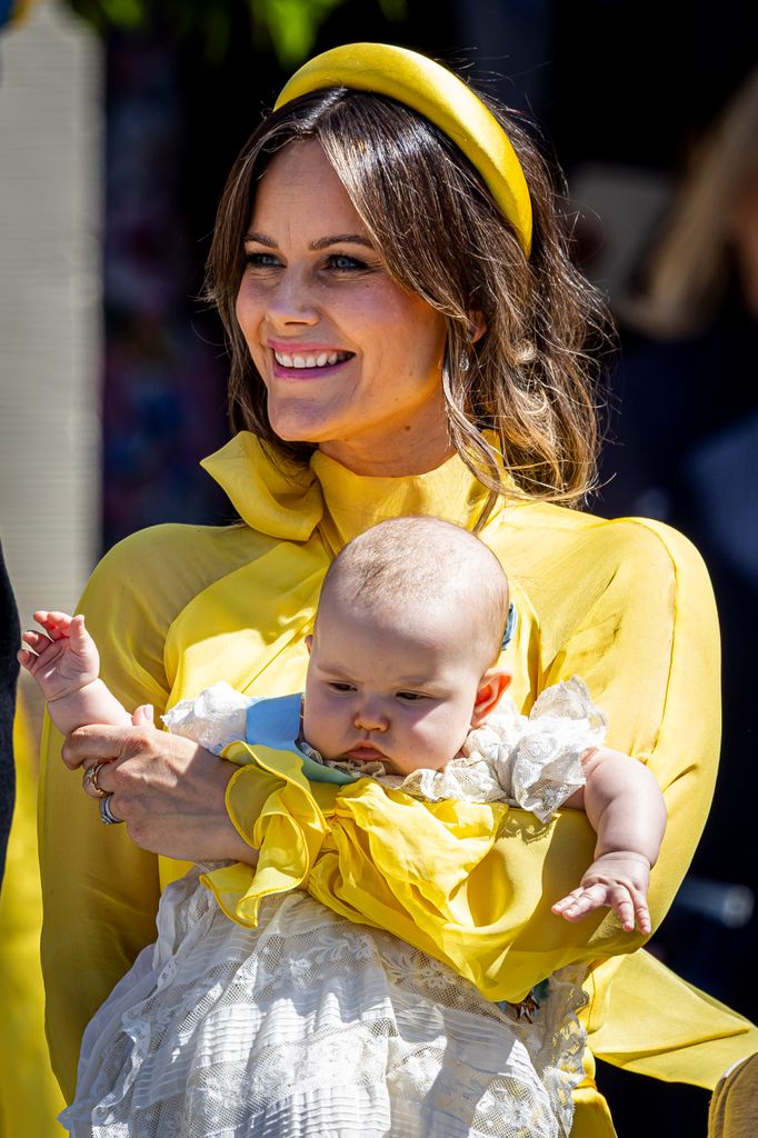 Princess Ines held by her mother Princess Sofia, wearing a Christening gown.