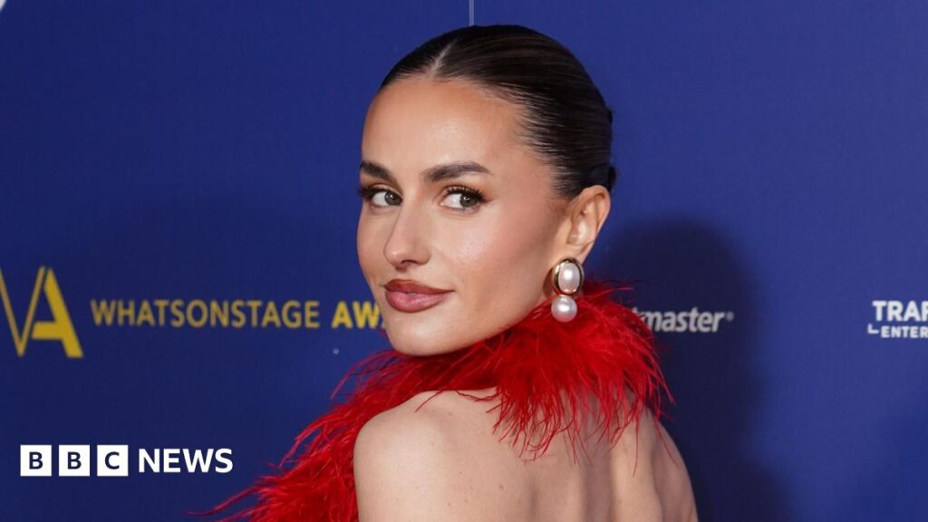 Amber Davies at the WhatsOnStage Awards wearing red feathered halterneck dress