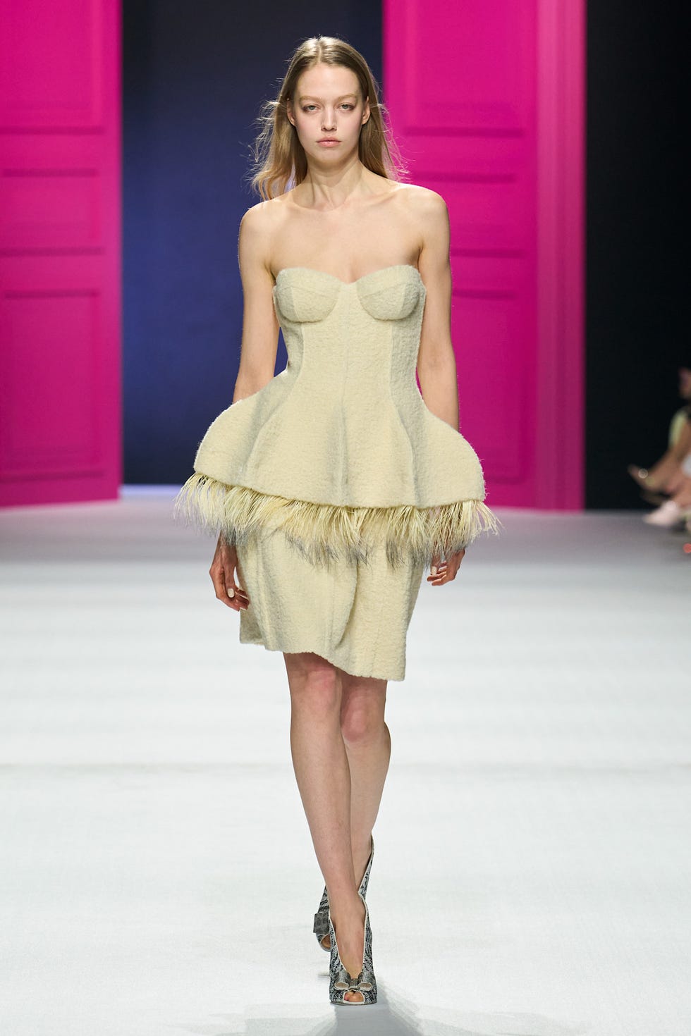 Model walking the runway in a unique fashion design.