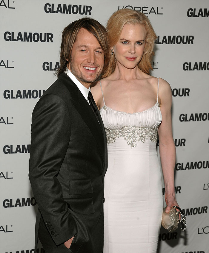 Nicole Kidman and Keith Urban posing together at a Glamour event in formal attire with smiles.