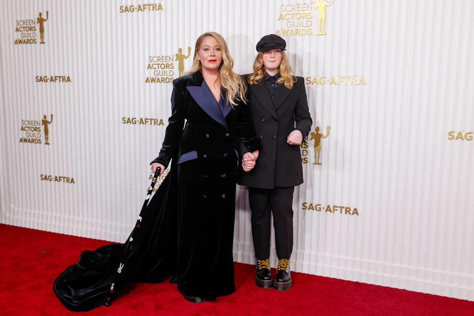Applegate poses on the red carpet at the Screen Actors Guild Awards, holding a cane and standing beside her daughter.