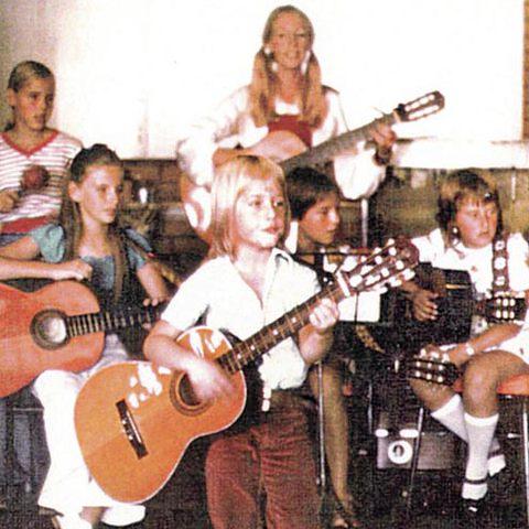 Keith Urban (center) plays the guitar at schoolCredit: Splash News Online