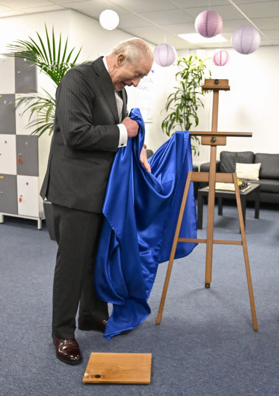 Britain's King Charles III reacts as he unveils a plaque which accidentally falls to the floor during a visit to Oxford Photovoltaics an enterprise developing advanced solar panels, in Kidlington, Oxfordshire, west of London on March 27, 2026. (Photo by Kate Green / POOL / AFP via Getty Images)Kate Green &sol; POOL &sol; AFP via Getty Images