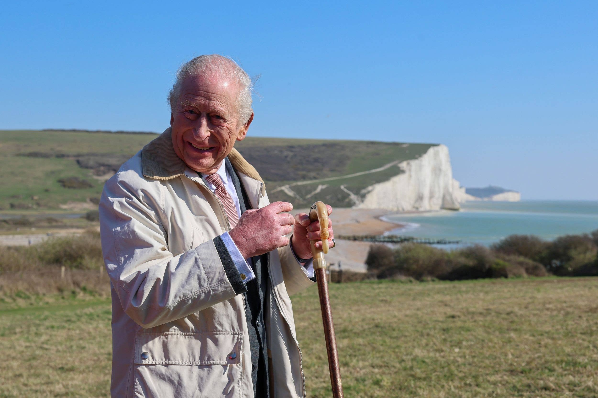 King Charles with a walking stick on a cliff walk