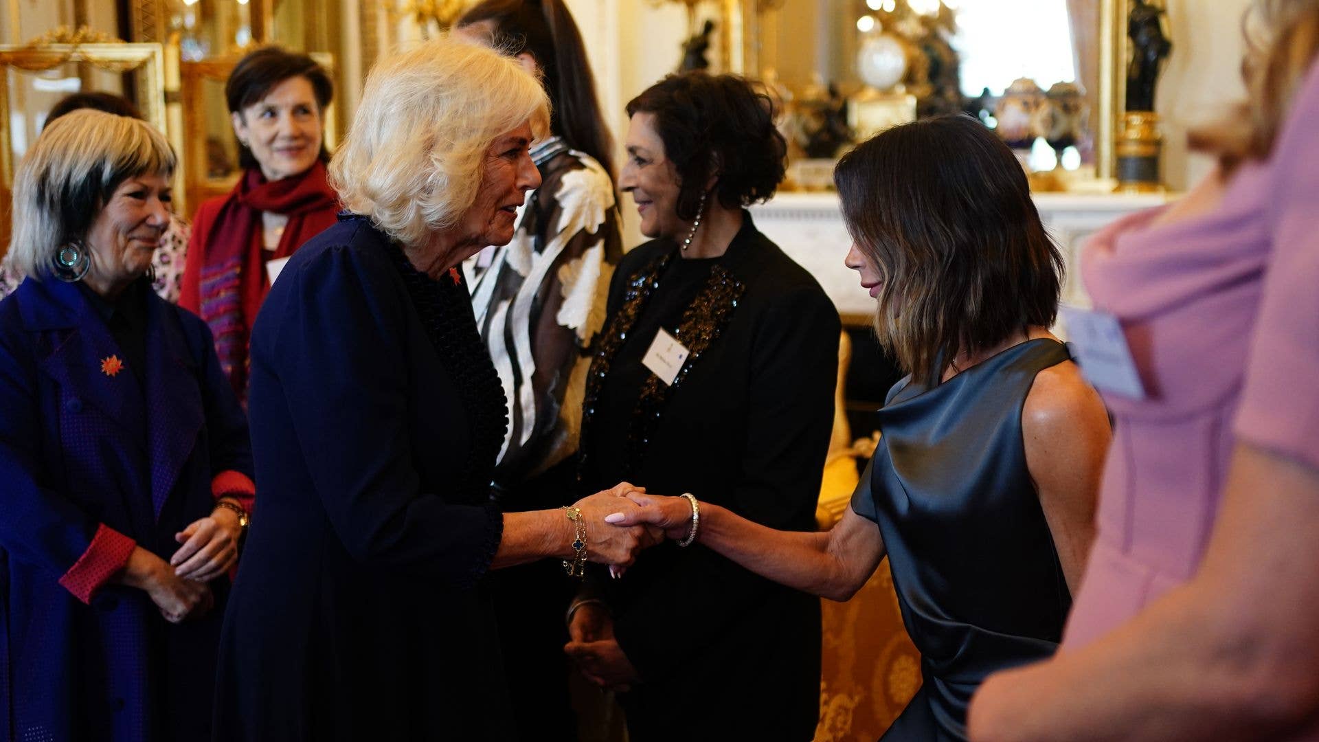 Victoria Beckham curtseying to Queen Camilla