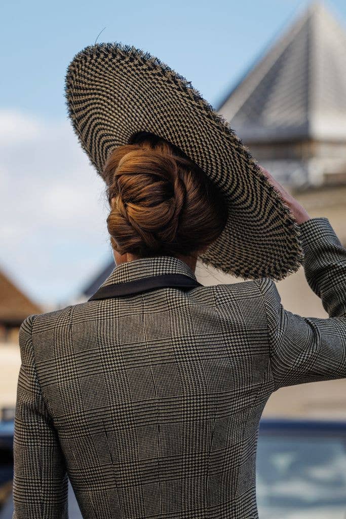 The Princess of Wales holds on to her hat from behind