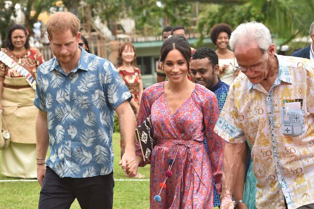 TOPSHOT - Britain's Prince Harry (L) and his wife Meghan, Duchess of Sussex arrive at the University of the South Pacific in Suva on October 24, 2018. - British royal Meghan Markle recounted her own struggles to afford university as she passionately promoted female education to Fijian students in her first speech of the Oceania royal tour on October 24. (Photo by Peter PARKS / AFP) (Photo credit should read PETER PARKS/AFP/Getty Images)