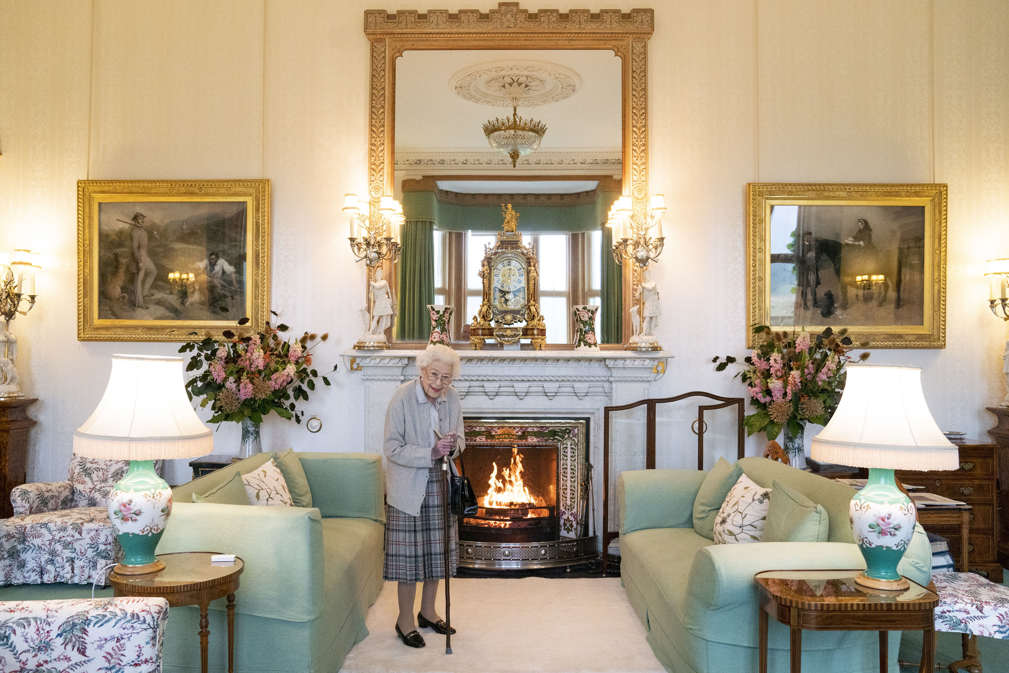 Queen Elizabeth standing in front of a fireplace at Balmoral