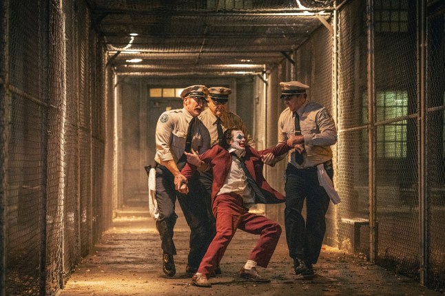 This image released by Warner Bros. Pictures shows Joaquin Phoenix, foreground center, and Brendan Gleeson, background center, in a scene from 