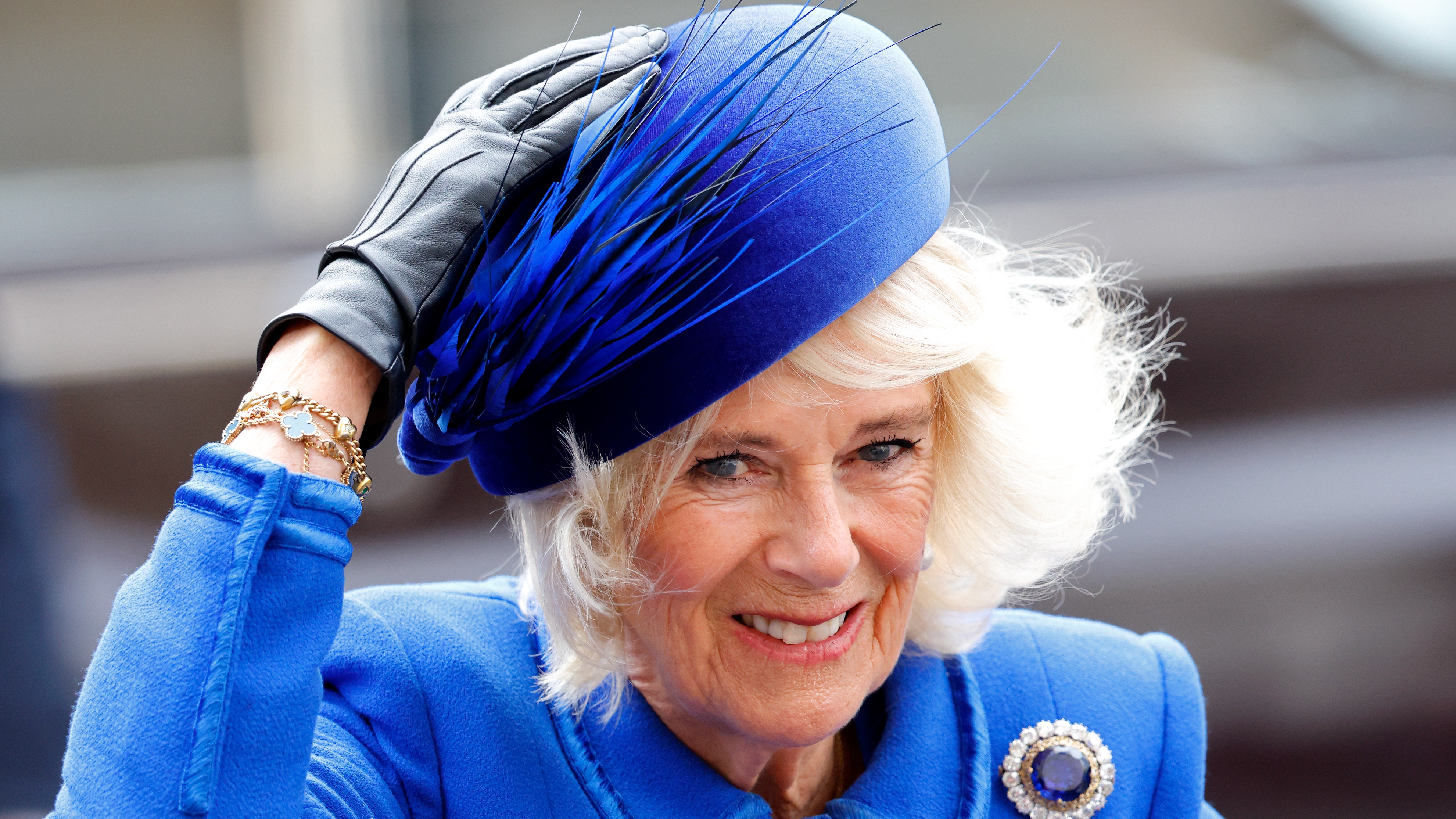 Queen Camilla holds onto her hat in the wind as she attends the 2023 Commonwealth Day Service